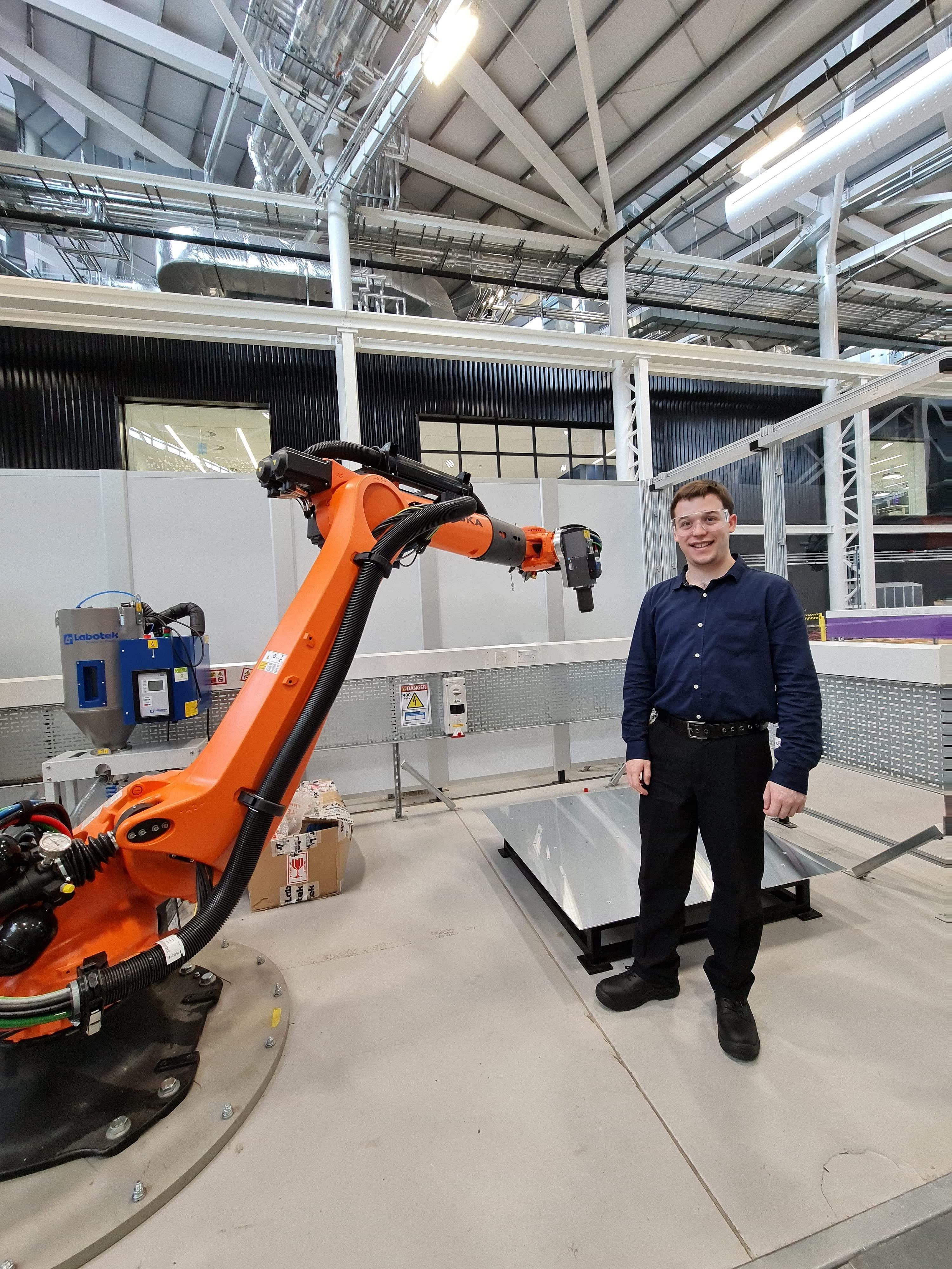 Man standing next to robotic machinery