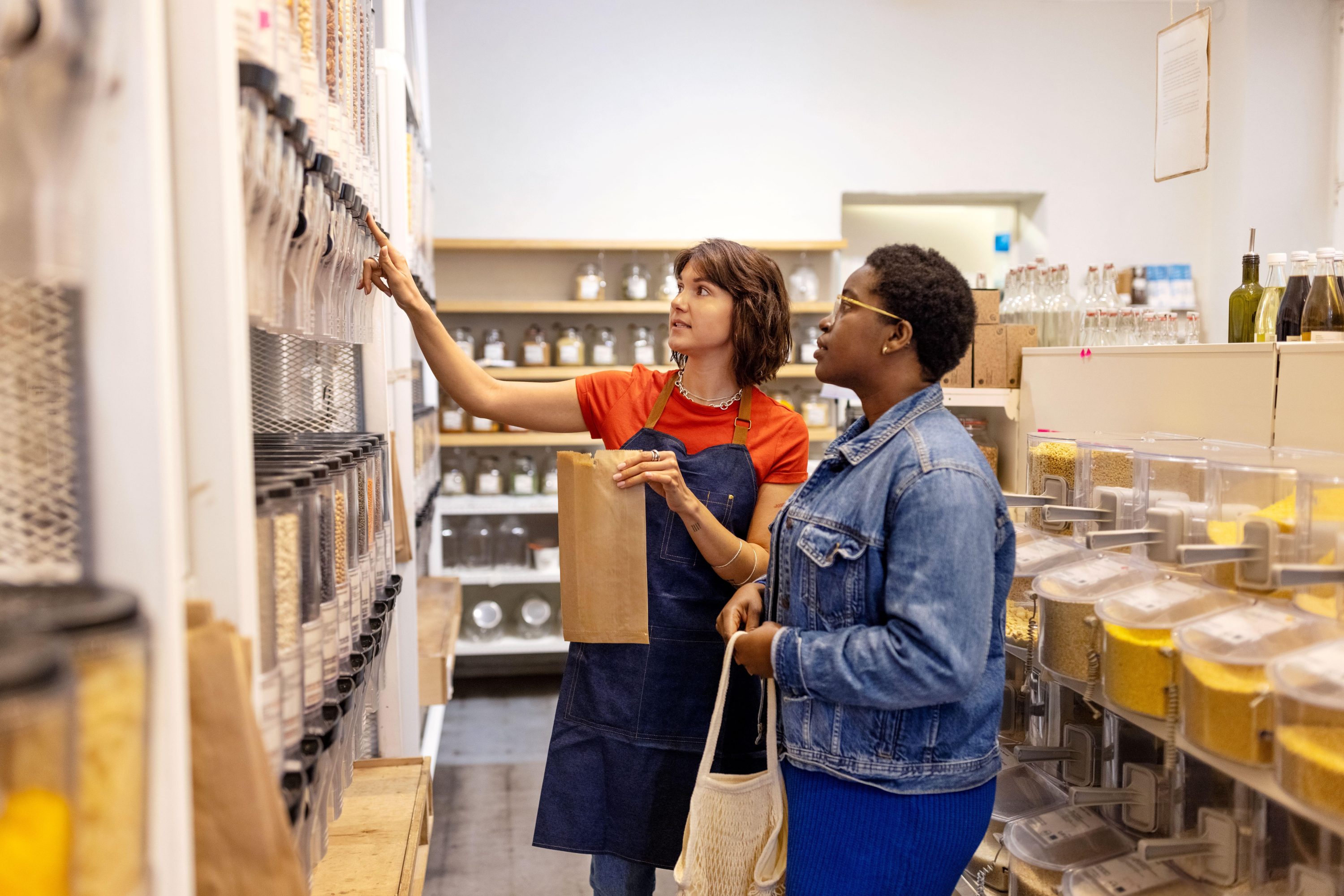 A small business workers and a customer looking at products on a shelf