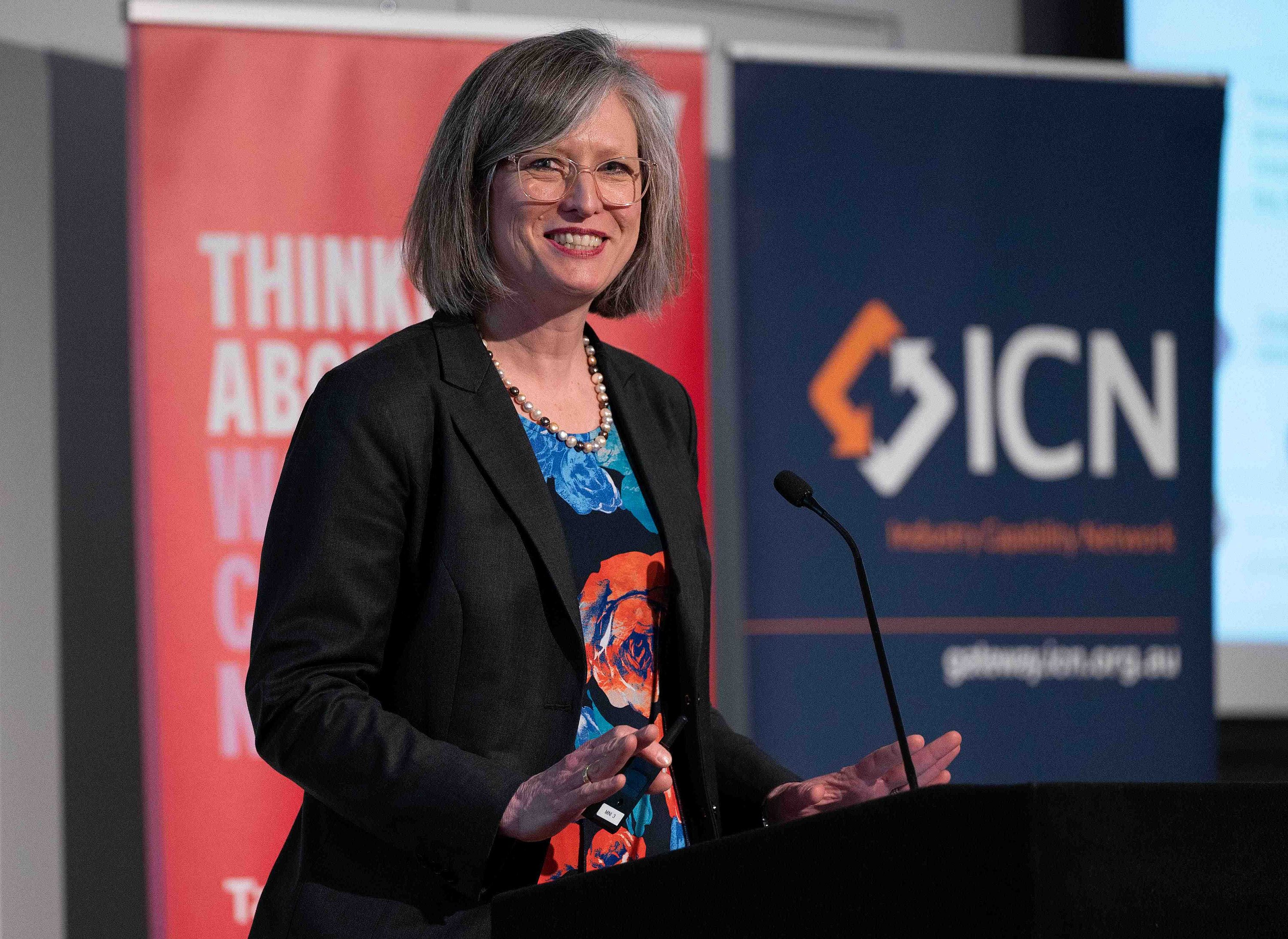 Bettina standing at a podium